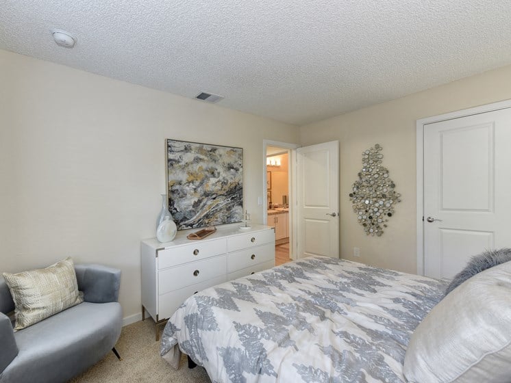 Bedroom with Attached Bath, Carpet, White Dresser and Gray Chair